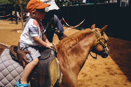 Johannesburg , Gauteng South Africa - April 27 2022 : young boy riding a pony for the first time midday Randburgのeditorial素材