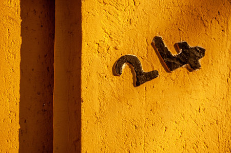 Old letter H on a yellow painted wall. Copy space.
