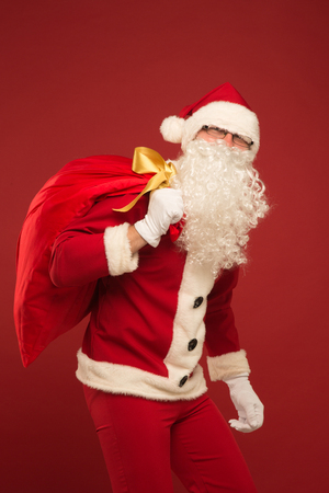 Santa Claus on a red background with giftsの写真素材