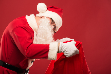 Santa Claus on a red background with giftsの写真素材