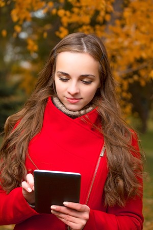 The young beautiful woman walks in autumn park.の写真素材