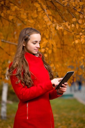 The young beautiful woman walks in autumn park.の写真素材