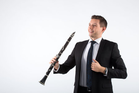 the young musician on a gray background plays the clarinetの写真素材