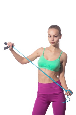 athletic girl with a skipping rope on a white backgroundの写真素材