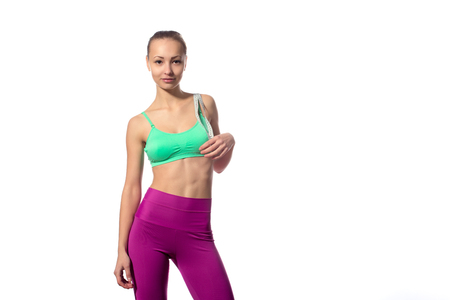 Fitness woman in sports style with a measuring tape standing on a white backgroundの写真素材
