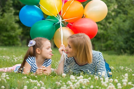 happy mother and daughter playing in the park with balloons. soft focusの写真素材