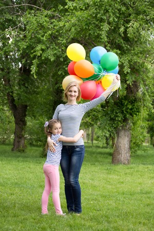 happy mother and daughter playing in the park with balloons. soft focusの写真素材