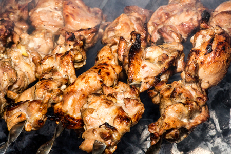 Grilled kebab cooking on metal skewer closeup. Roasted meat cooked at barbecue. BBQ fresh beef meat chop slices. Traditional eastern dish, shish kebab. Grill on charcoal and flame, picnic, street foodの写真素材