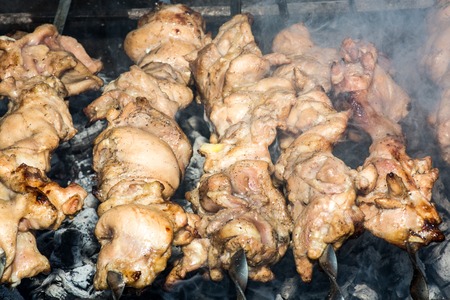 Grilled kebab cooking on metal skewer closeup. Roasted meat cooked at barbecue. BBQ fresh beef meat chop slices. Traditional eastern dish, shish kebab. Grill on charcoal and flame, picnic, street foodの写真素材