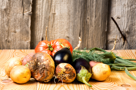 Set of different fresh raw colorful vegetables near the wooden tray, light backgroundの写真素材