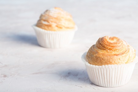 Fresh baked golden muffins on rustic wooden background shot in natural lightの写真素材