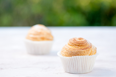 Fresh baked golden muffins on rustic wooden background shot in natural lightの写真素材