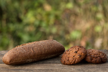 Assortment of fresh baked goods wooden background. baguette and cookies in the open space