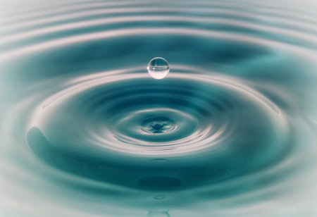 Water droplets fall down closely into the dark blue water, making it the perfect center in nature.