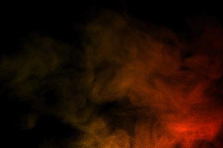 close-up of floating colorful steam smoke spray isolated on a black backgroundの写真素材