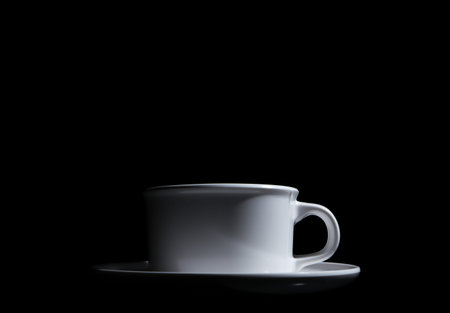 white ceramic cup. isolated on a black background. with copy space for adding text