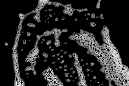 liquid white foam diffuses abstract bubbles on a black background