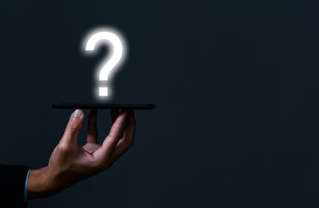 Businessman hand holding a smartphone showing a question mark icon. Alternative ideas, ideas,...