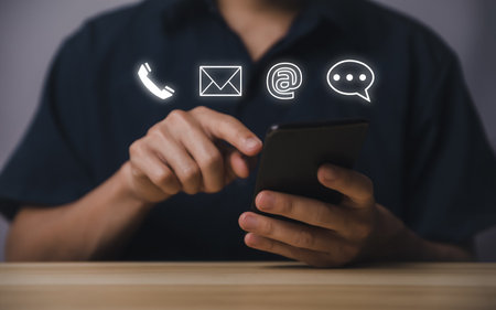 Businessman using smartphone showing icon of phone, email, address, live chat. Contact us concept for customer service center connection. Communication on the Internet through the websiteの写真素材
