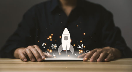 the smartphone shows a rocket and an icon. Concept of Startup Business, Entrepreneurship Idea, and...