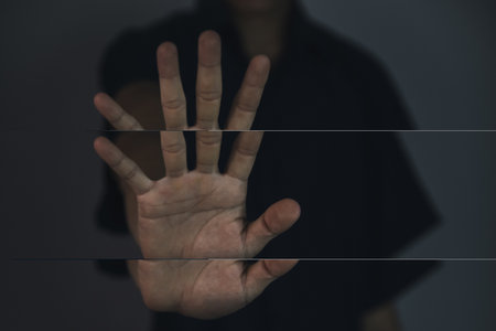 male hand showing stop gesture Concept of stop violence. Warning, prohibition, denial. On dark background.の写真素材