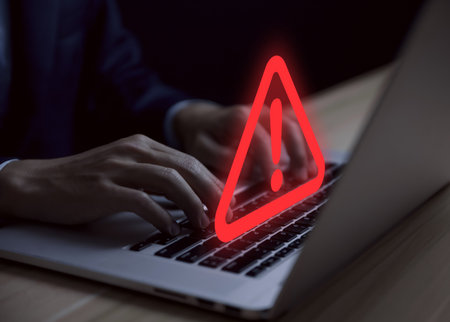 Businessman using laptop showing warning triangle and exclamation sign icon Warning of dangerous problems Server error. Virus. Maintenance concept. caution internet technology network securityの写真素材