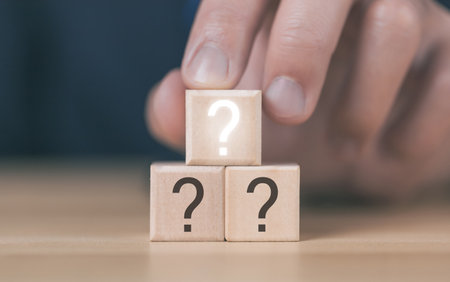 The wooden cube block shows a question mark icon. The concept of choice. Confusion. Business solution. copy spaceの写真素材