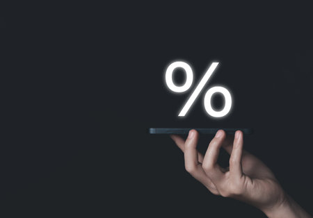 Businessman hand holding smartphone showing percentage sign business investment concept, increase stock profit, finance, marketing, sale, interest rate Better economy and discountsの写真素材
