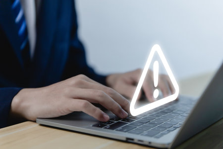 Businessman using laptop showing warning triangle and exclamation sign icon Warning of dangerous problems Server error. Virus. Maintenance concept. caution internet technology network securityの写真素材