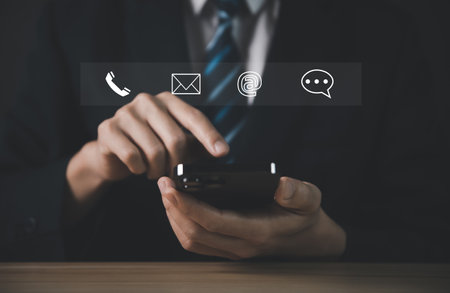 Businessman using smartphone showing icon of phone, email, address, live chat. Contact us concept for customer service center connection. Communication on the Internet through the websiteの写真素材