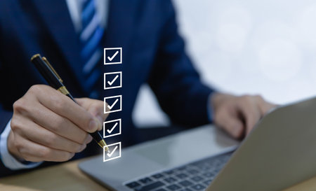 Businessman hand holding a pen ticking checkmark on a box in the list Show on the virtual screen. Checklist Ideas in Business Survey items and questionnaires. copy spaceの写真素材