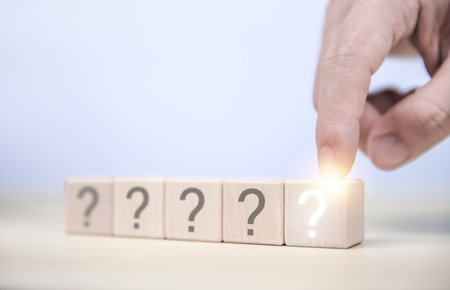The wooden cube block shows a question mark icon. The concept of choice. Confusion. Business solution. copy spaceの写真素材