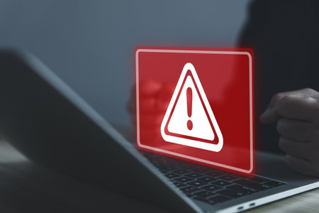 Businessman using laptop showing warning triangle and exclamation sign icon Warning of dangerous problems Server error. Virus. Maintenance concept. caution internet technology network securityの写真素材