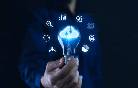 Businessman holding a light bulb showing a diagram of Cloud computing information technology icon....
