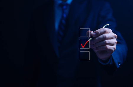 Businessman ticking checkmark on a box in the list Show on the virtual screen. Checklist Ideas in Business Survey items and questionnaires. copy spaceの写真素材