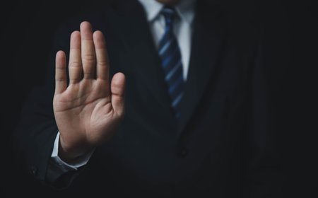 male hand showing stop gesture Concept of stop violence. Warning, prohibition, denial. On dark...