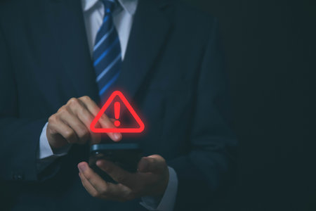 Businessman using laptop showing warning triangle and exclamation sign icon Warning of dangerous problems Server error. Virus. Maintenance concept. caution internet technology network securityの写真素材