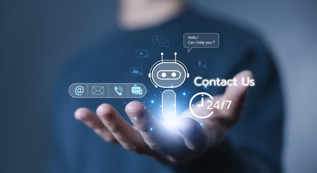 Hand holding AI chatbot contact support hologram with 24/7 service icons, representing artificial...