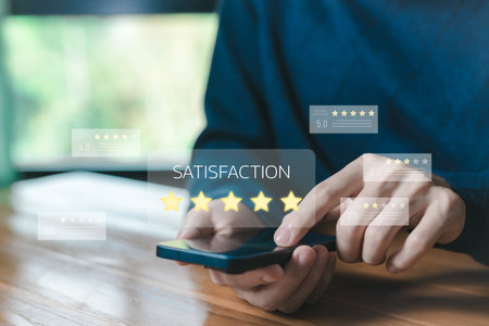 Customer satisfaction rating concept. man using smartphone, showing five-star review, feedback, and online evaluation for business service quality and digital customer experience management.の写真素材