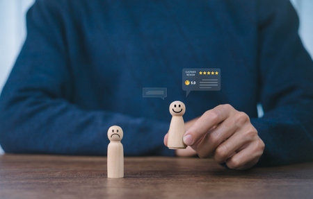 Customer satisfaction concept. hand holding a wooden figure and five star rating icon, symbolizing positive feedback, user experience, product review, and business reputation improvement.の写真素材