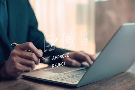 Businessman approving document on digital platform using laptop, concept for online contract, e-signature, workflow automation, and paperless office in modern business management. approving onlineの写真素材