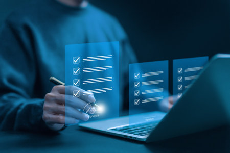 Digital signature and electronic checklist concept. Businessman using stylus pen to sign digital documents on virtual screen via laptop. Paperless process, online contract and form approval.の写真素材