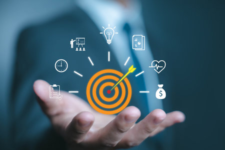 Businessman holding digital target with dart arrow, symbolizing goal setting, business strategy, success planning, achievement, performance, and corporate objectives in professional development.の写真素材