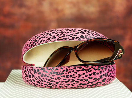 Pink sunglasses case on gray shaped groundの写真素材