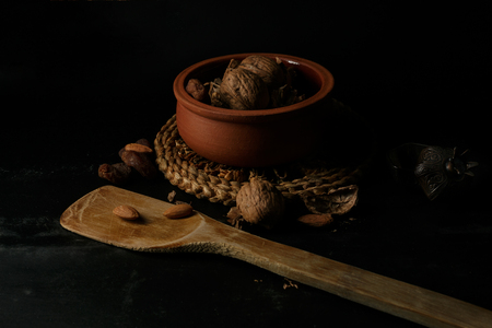 Still life with walnuts, almonds, dried apricots in dark sceneの写真素材