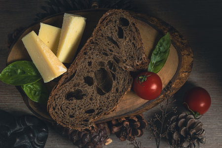 Bread, cheese, tomatoes and basil on a wooden background.の写真素材