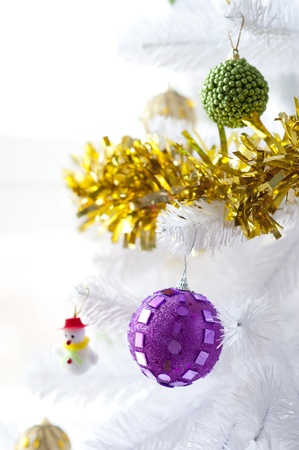 Scene with some baubles and a little snowman holding from a beautiful Christmas treeの写真素材