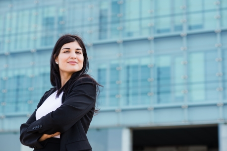 Youn entrepeneur cross her arms in front of a buildlingの写真素材