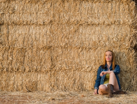Pretty girl in a hay straw with lot of copy spaceの写真素材
