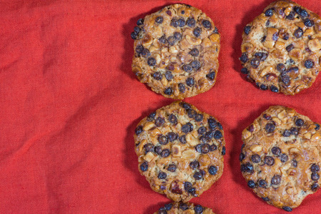 Oats cookies with hazelnuts and chocolate chips on a red clothの写真素材